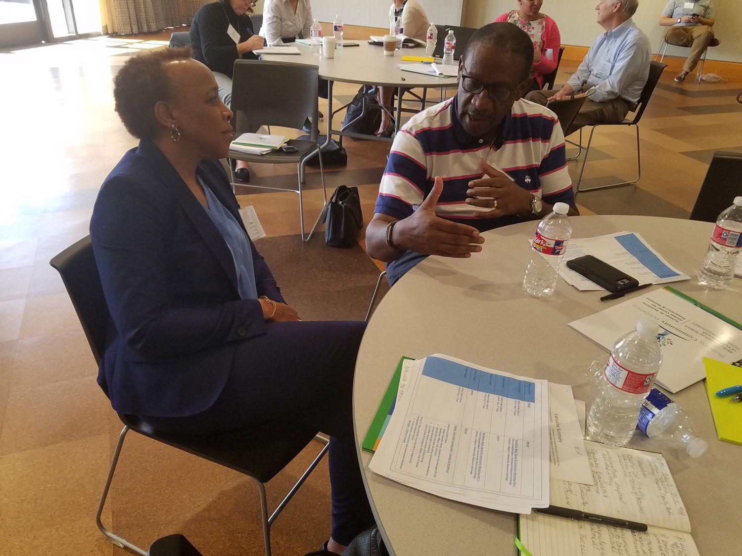 Two people talk at conference meeting